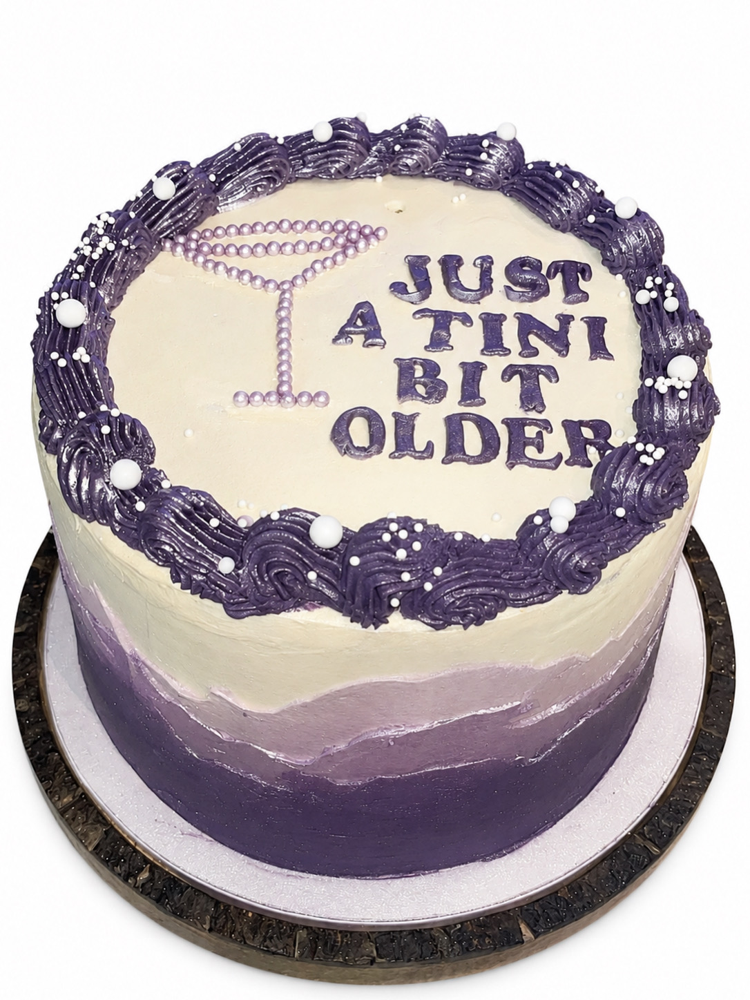Purple ombre birthday cake with a piped martini glass and 'Just a tini bit older' lettering